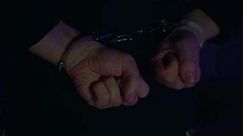 Close Up of Handcuffed Hands in Dark Lighting