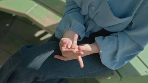 Woman Sits with Hands on Knees