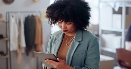 Woman Using Tablet in Clothing Business