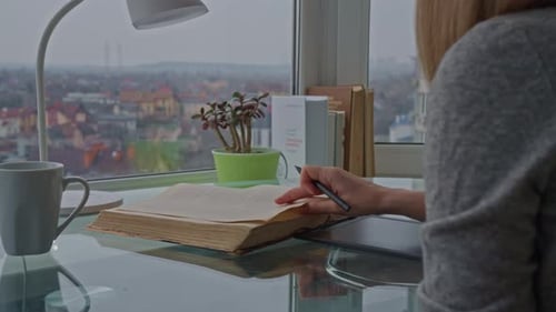 Woman Reads an Old Book at a Desk
