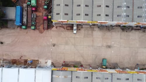Aerial view of a goods distribution warehouse lined up with goods trucks parked in front of the ware
