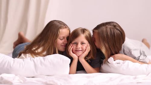 Three Happy Girls Lying on Bed Together