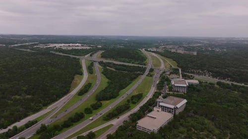 Aerial View of Traffic in Highways Surrounded By Lush Greenery and a Mix of Residential and