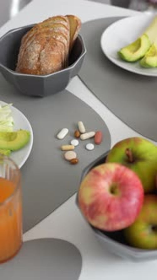 Vista vertical de la escena de un desayuno saludable con vitaminas y pastillas