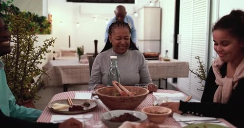 Happy african family cooking and eating healthy dinner together at home terrace