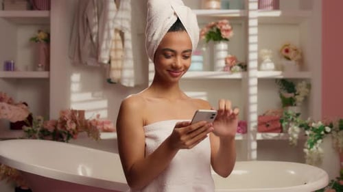 Happy Woman in Towel Using Smartphone in Bathroom