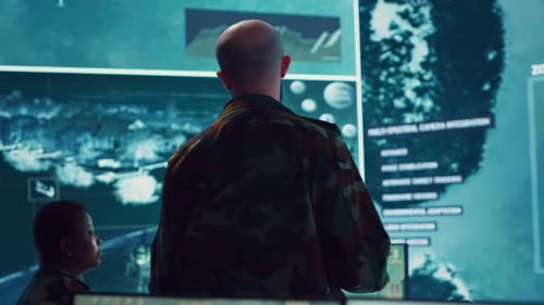 Army Officer Examining Real Time Satellite Data on Big Screen in Military Base