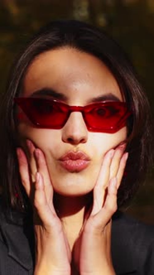 Stylish young woman wearing red sunglasses