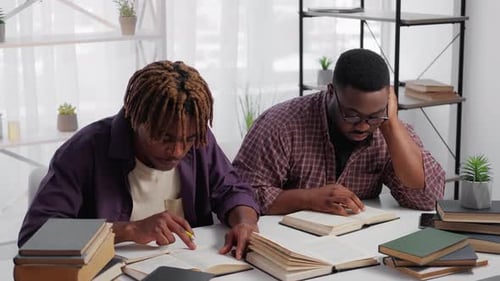 Two Young Adults Studying Together With Books