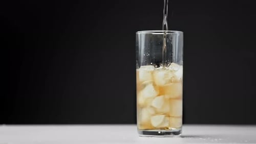 Refreshing Beverage Poured into Glass with Ice
