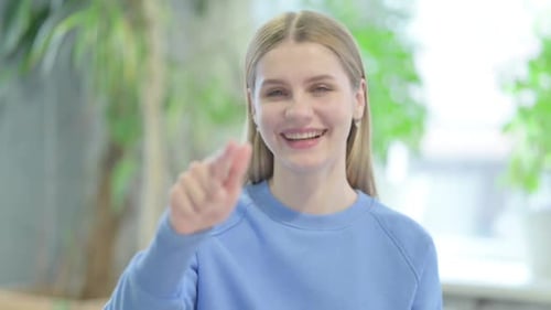Portrait of Casual Young Woman Pointing at the Camera