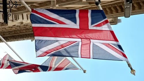 Vista vertical cercana de las banderas del Reino Unido ubicadas en la fachada de un edificio en el centro de Londres