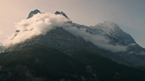 Clouds moving over the face of mountain at sunset in the Swiss Alps
