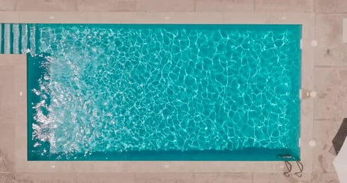Blue Water in the Swimming Pool with Light Reflections