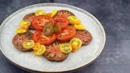 Tomaten auf rotierendem Teller mit durchgehendem Topf. Teller mit gesunden Bio-Tomaten, gesundes vegetarisches Gemüse