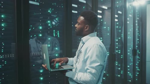 Man Working on Laptop in Data Center