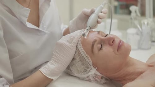 Woman Receives Facial Treatment at Cosmetology Clinic
