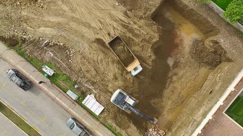 Construction Site Excavator and Dump Truck Working Aerial View