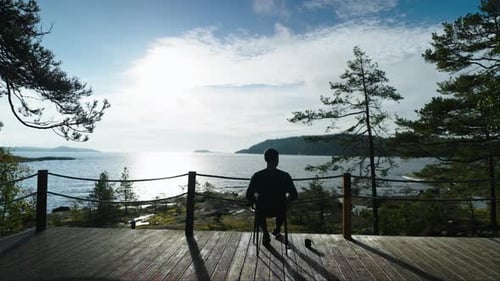 Lonely Man Resting On Balcony In Morning Dark Silhouette Of Sitting Person On Chair On Terrace