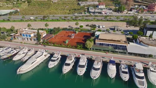 Aerial Video Scenic Aerial Perspective of a Tennis Club By a Harbor With White Yachts and Azure