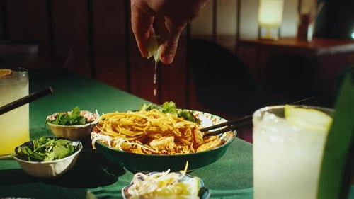 Eating Pad Thai Noodles with Shrimp Using Chopsticks in Restaurant