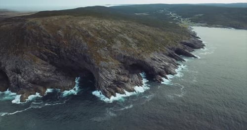 Wide aerial view of beautiful coastline in Eastern Canada. Blue sea meets rugged shore with small to