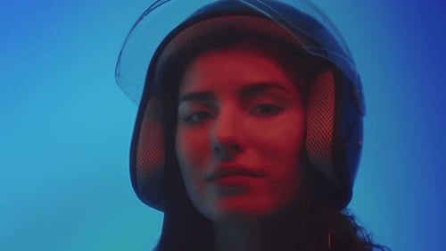 Stylish Woman in Motorcycle Helmet with Dramatic Lighting