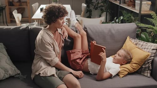 Woman and Girl Reading a Book on Couch
