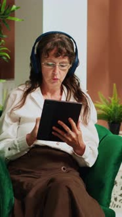 Woman Using Tablet While Sitting on Green Chair