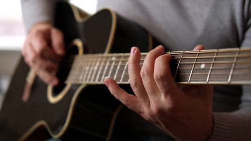 Hands Play Chords on Acoustic Guitar Close Up