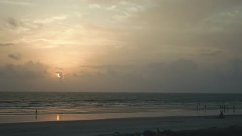 Warmes Licht der untergehenden Sonne, das goldene Reflexe auf die sanften Wellen und den nassen Strand wirft