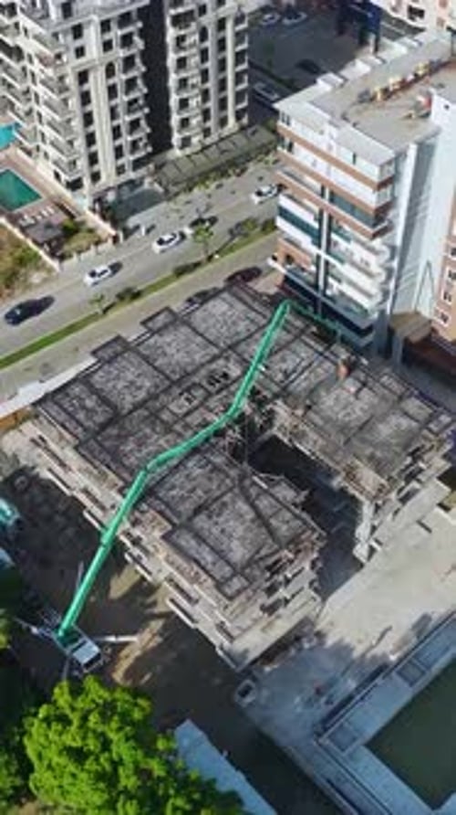 Vertical Video Residential Complex Worksite with Concrete Pouring and Active Construction Tasks