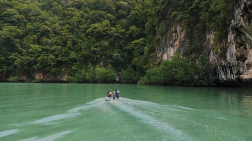 Viajero asiático en barco por la laguna paradisíaca con agua turquesa