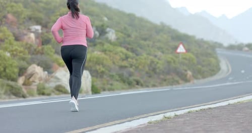Jogging on mountain road, woman in athletic wear enjoying outdoor exercise, copy space
