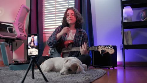 Young Adult Plays Guitar for Smartphone Video