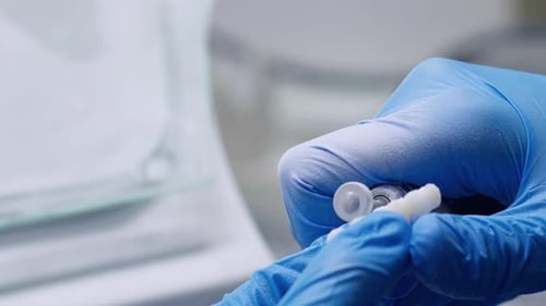 Gloved Hands Preparing Medicine in Clinical Setting