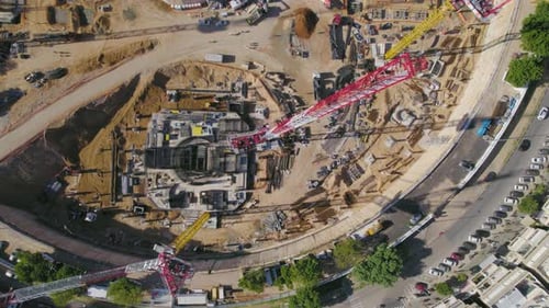 de arriba hacia abajo sobre Tower Crane en una obra en construcción en la plaza de una gran ciudad mientras pasan los coches
