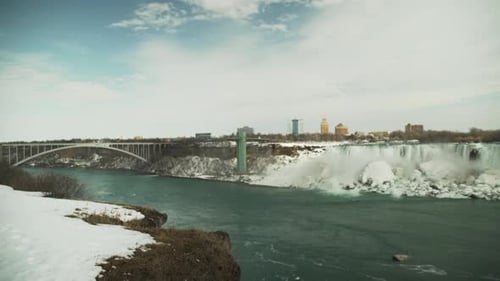 Niagara Falls and the Rainbow Bridge in snowy winter, wide static view