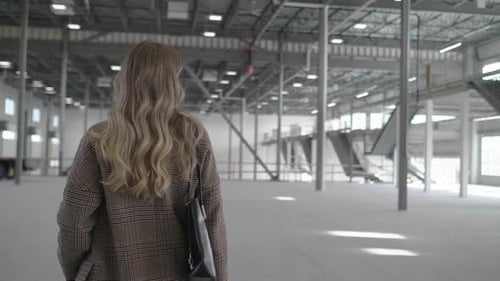 Female Inspector in Large Empty Warehouse Adult