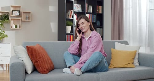 Woman Smiling and Talking on Her Phone on Couch
