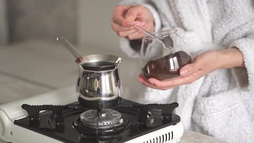 Woman Preparing Coffee in a Silver Pot