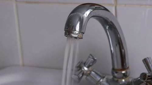 Opening the Faucet and Stream of Water Pouring From ChromePlated Tap