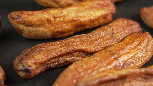 Close Up of Caramelized Bananas on Dark Surface
