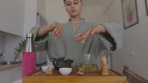 Young Adult Preparing Tea with Wooden Stick