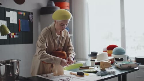 Woman in Hat Store Working with Thumbtacks