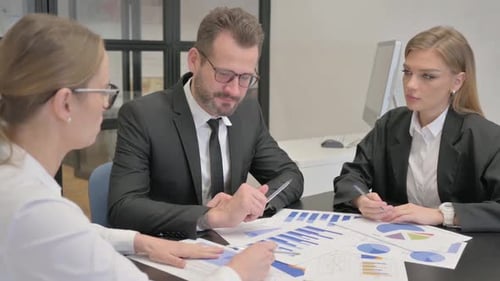 Business Team Analyzes Financial Data at Conference Table
