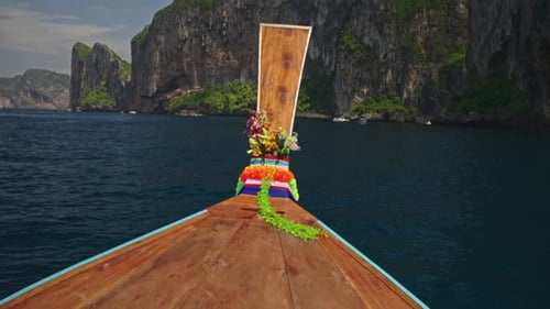 A Boat is Floating on Top of a Body of Water with Mountains in the Background