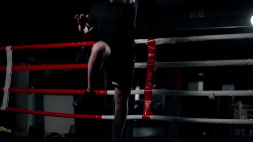Midair Strikes A Man Makes Jumping Kicks Sports Training in a Dark Hall