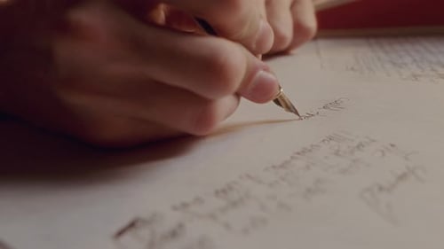 Male Hand Writing Text on Paper Page with Fountain Pen