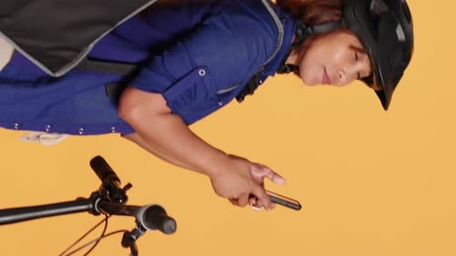 Woman on Bike Checking Her Cellphone